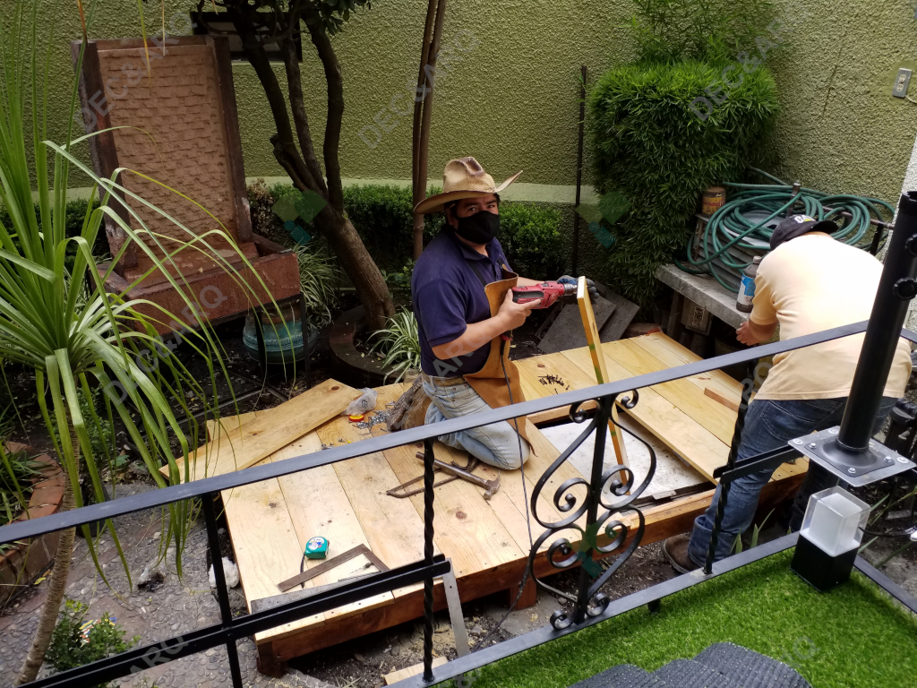 Hombre instalando una base de madera en el jardín
